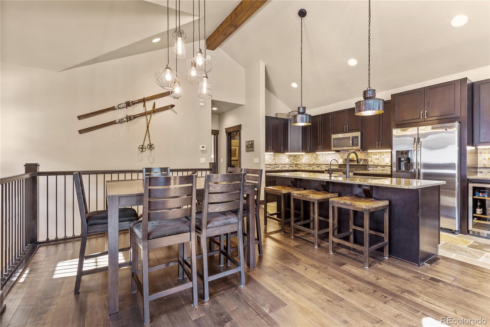68 Independence Road Keystone, CO 80435 - Photo 9 of 34 a kitchen with stainless steel appliances kitchen island granite countertop a table chairs and a wooden floor