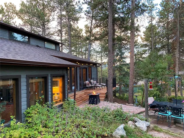 a view of a chair and table in backyard of the house