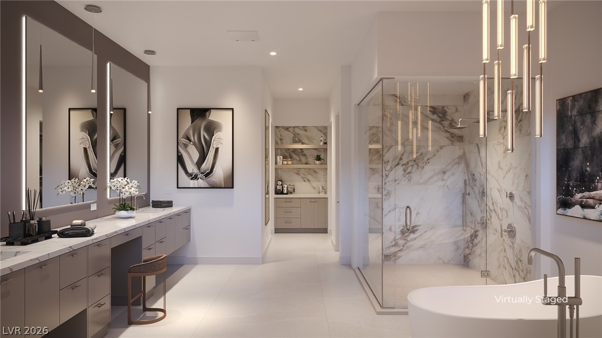 505 Overlook Rim Drive Henderson, NV 89012 - Photo 13 of 22 A well-lit, contemporary primary bathroom featuring dual vanities, a glass-enclosed shower, and a freestanding tub.