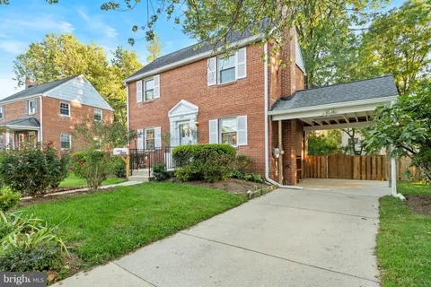 a front view of a house with a yard and potted plants