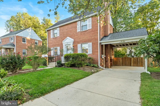 a front view of a house with a yard and potted plants