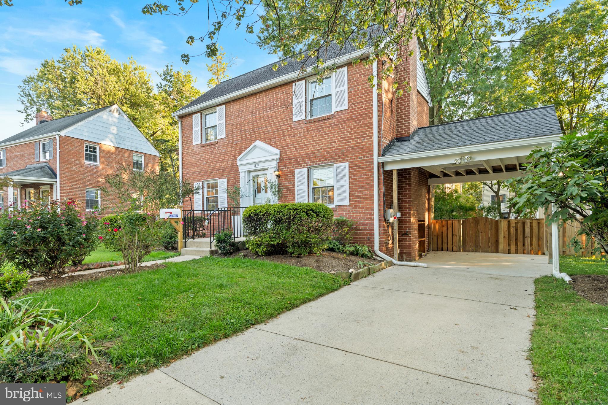 Charming brick home with lush greenery.