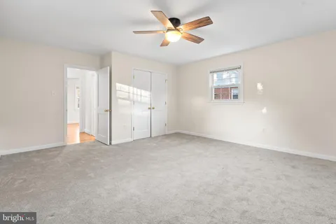 an empty room with a ceiling fan and a window