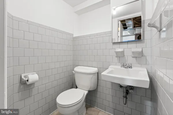 a bathroom with a toilet a sink and mirror