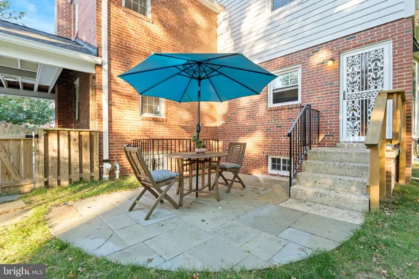 a view of a patio with a table and chairs under an umbrella