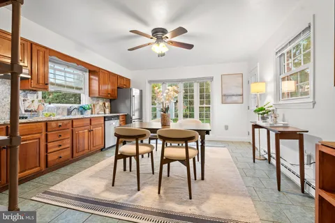 a dining room with wooden floor a chandelier a wooden table and chairs