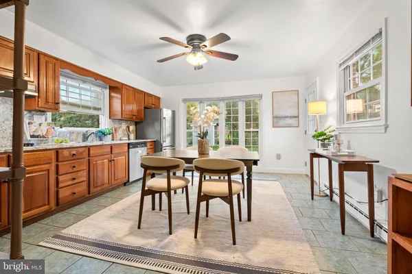a dining room with wooden floor a chandelier a wooden table and chairs
