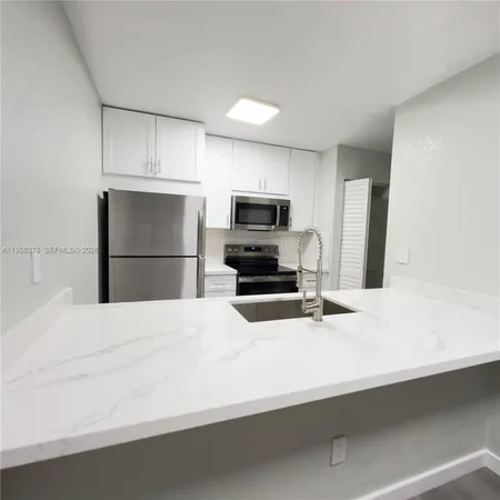 a kitchen with a refrigerator and a sink