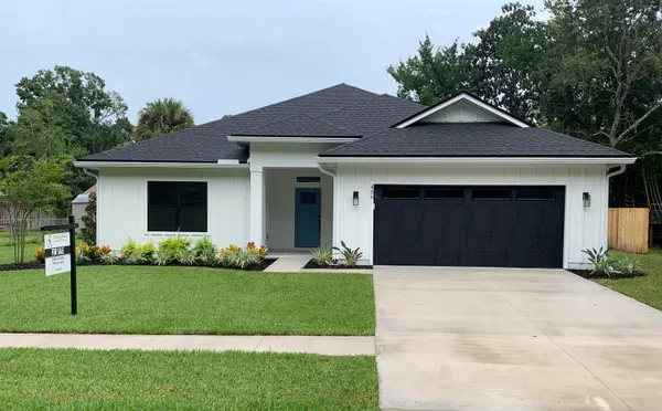 a front view of a house with a yard and garage