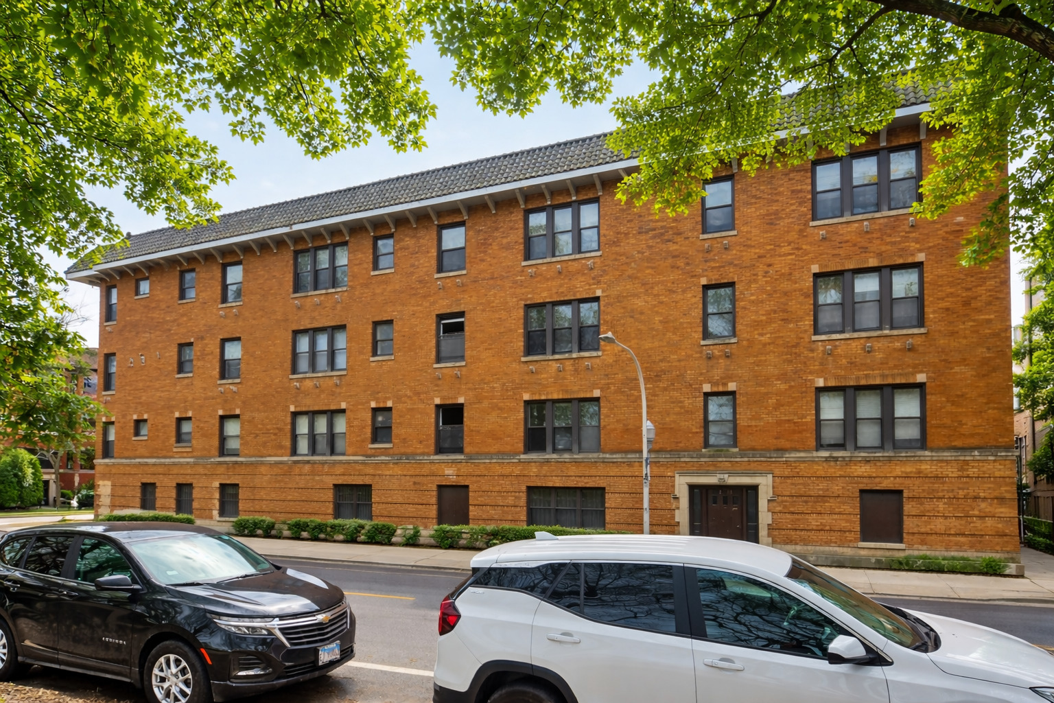 2125 East 67th Street, Unit 2E Chicago, IL 60649 - Photo 1 of 5 a view of a cars park in front of a building