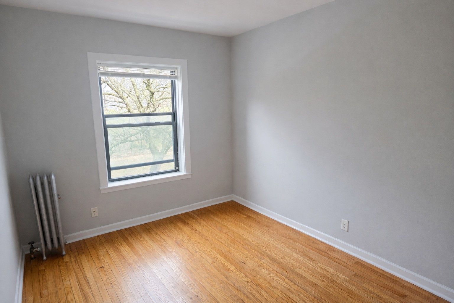 2125 East 67th Street, Unit 2E Chicago, IL 60649 - Photo 3 of 5 an empty room with wooden floor and windows