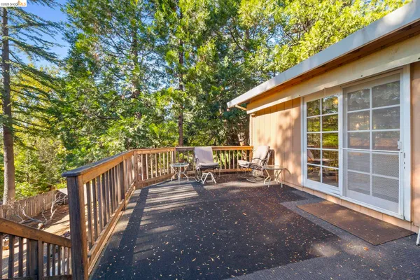a view of a deck with chairs and wooden fence