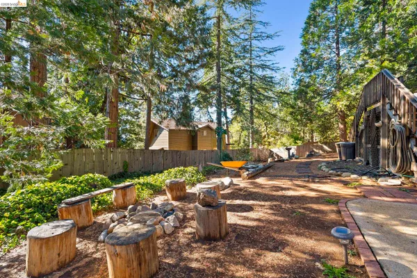a view of a backyard with table and chairs couches under an umbrella