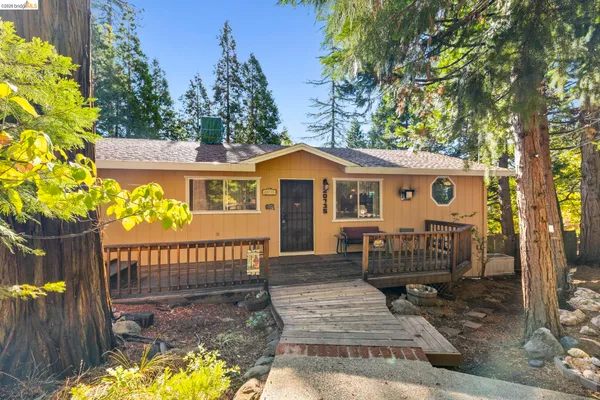 a view of a house with a wooden bench in a patio