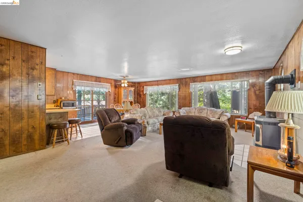 a living room with furniture a flat screen tv and a floor to ceiling window
