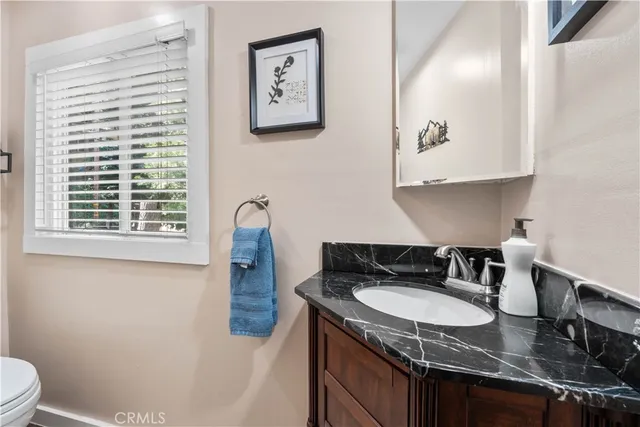 a bathroom with a granite countertop sink and a mirror
