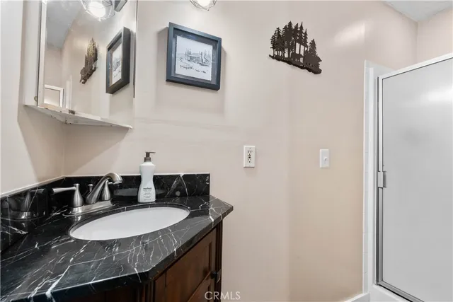 a bathroom with a granite countertop sink a mirror and a lamp