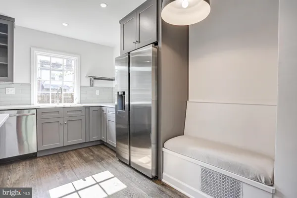 a kitchen with white cabinets and refrigerator