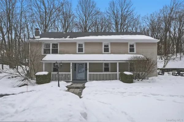 a front view of a house with a yard covered in snow
