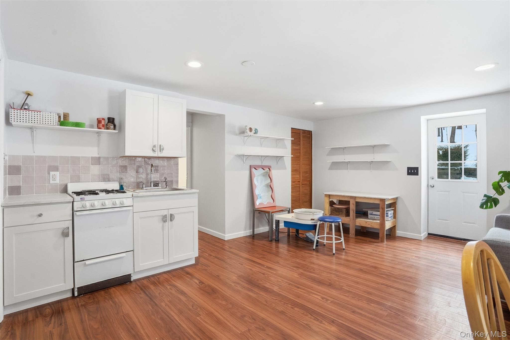 44 Triangle Of Clearwater Road Highland, NY 12528 - Photo 31 of 48 a kitchen with stainless steel appliances granite countertop a stove top oven a sink a dining table and chairs with wooden floor