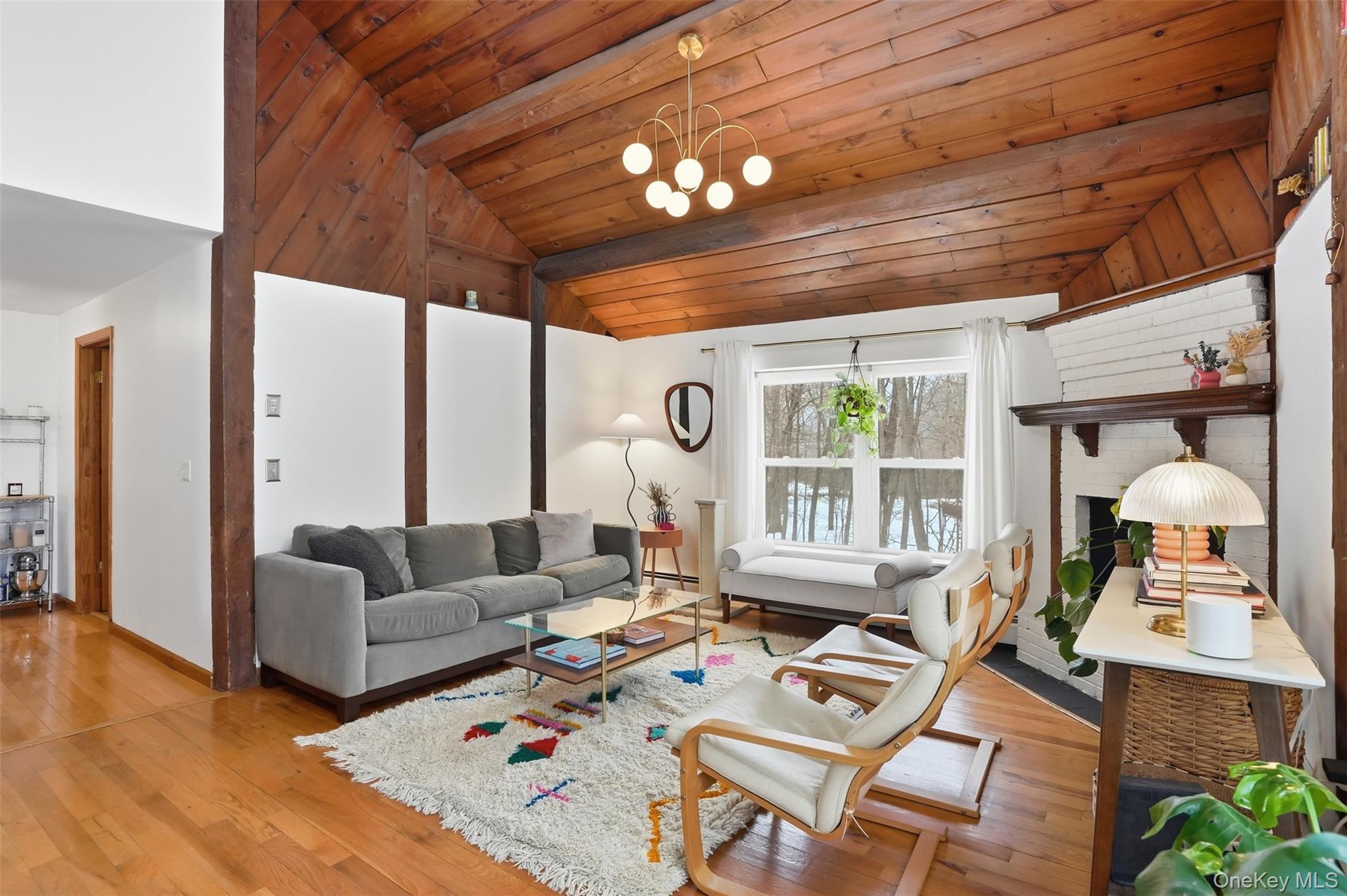 44 Triangle Of Clearwater Road Highland, NY 12528 - Photo 9 of 48 a living room with furniture a chandelier and a dining table with wooden floor