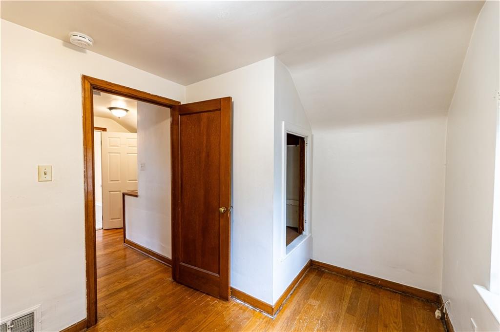 531 Beulah Road Pittsburgh, PA 15235 - Photo 21 of 32 a view of an empty room with wooden floor and a bathroom