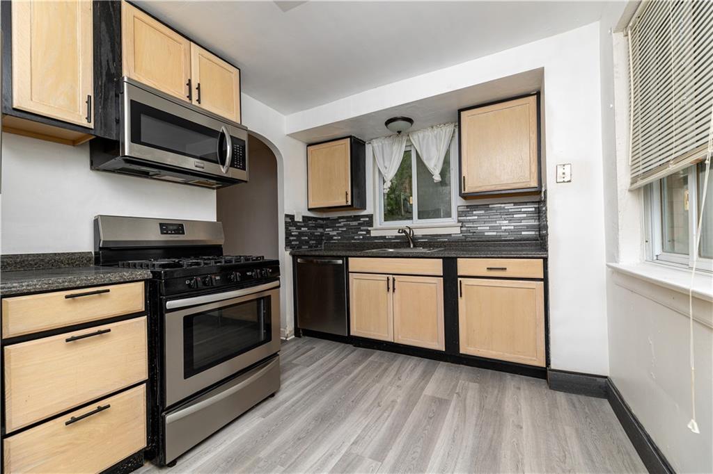 531 Beulah Road Pittsburgh, PA 15235 - Photo 10 of 32 a kitchen with stainless steel appliances granite countertop a stove and a microwave