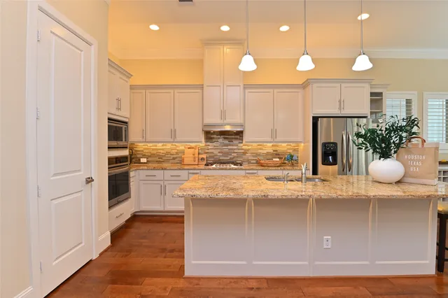 a kitchen with stainless steel appliances granite countertop a refrigerator a stove and a cabinets