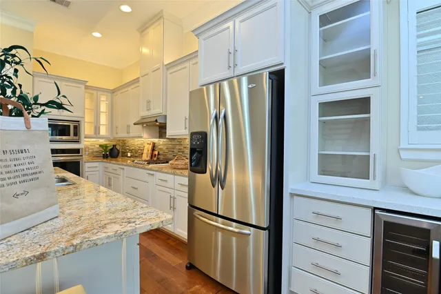a kitchen with kitchen island granite countertop appliances cabinets and a counter space