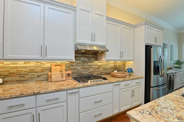 a kitchen with granite countertop a sink stainless steel appliances and cabinets