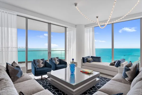 a living room with furniture kitchen view and a large window