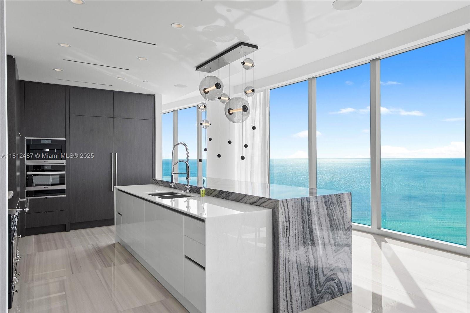 17901 Collins Avenue, Unit 3004 Sunny Isles Beach, FL 33160 - Photo 12 of 61 a kitchen with stainless steel appliances granite countertop a refrigerator and a stove