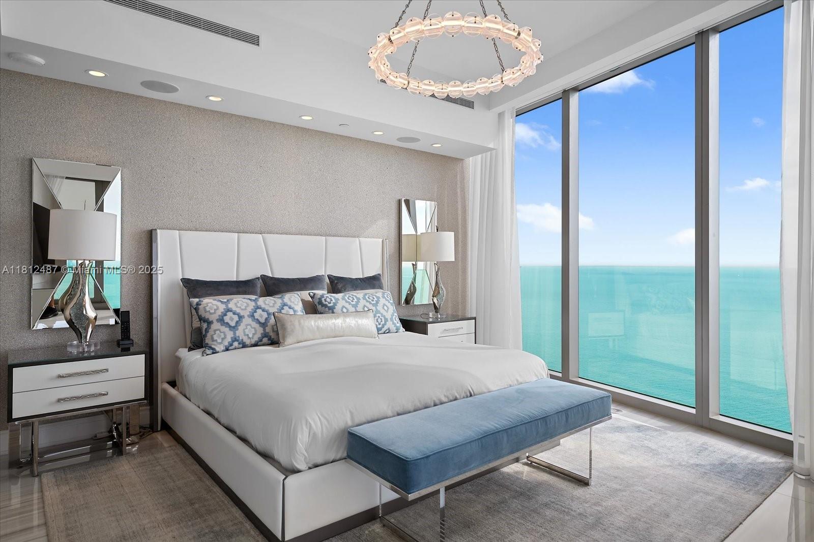 17901 Collins Avenue, Unit 3004 Sunny Isles Beach, FL 33160 - Photo 18 of 61 a bedroom with a bed and a chandelier