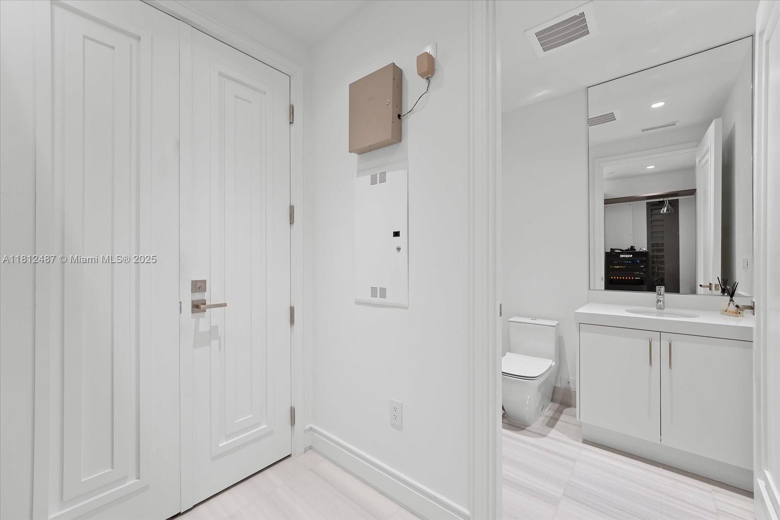 17901 Collins Avenue, Unit 3004 Sunny Isles Beach, FL 33160 - Photo 28 of 61 a bathroom with a toilet a sink and mirror