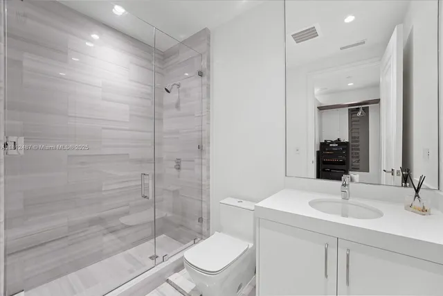 a bedroom with a bed and a flat tv screen on dresser