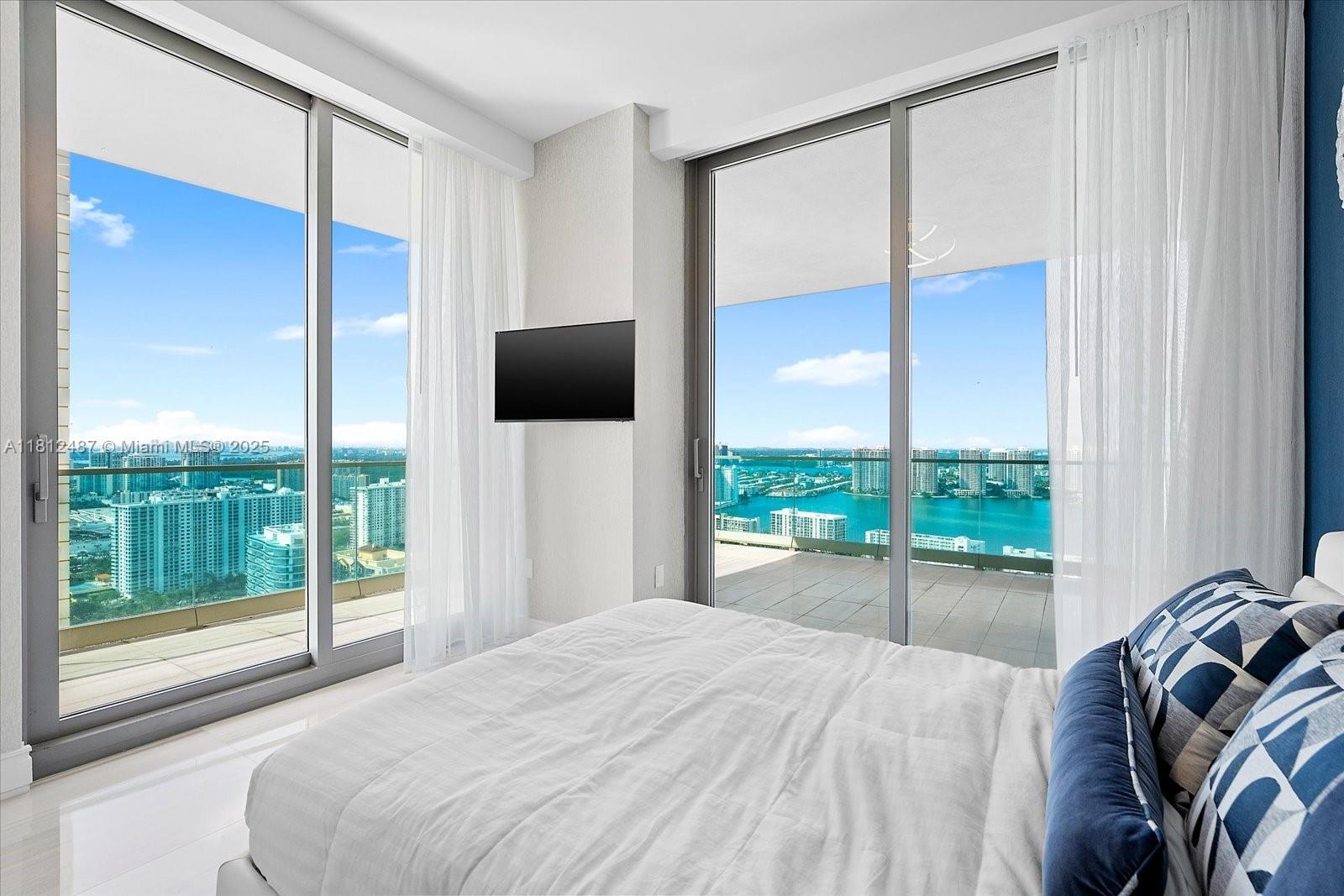 17901 Collins Avenue, Unit 3004 Sunny Isles Beach, FL 33160 - Photo 34 of 61 a bedroom with a bed and glass door