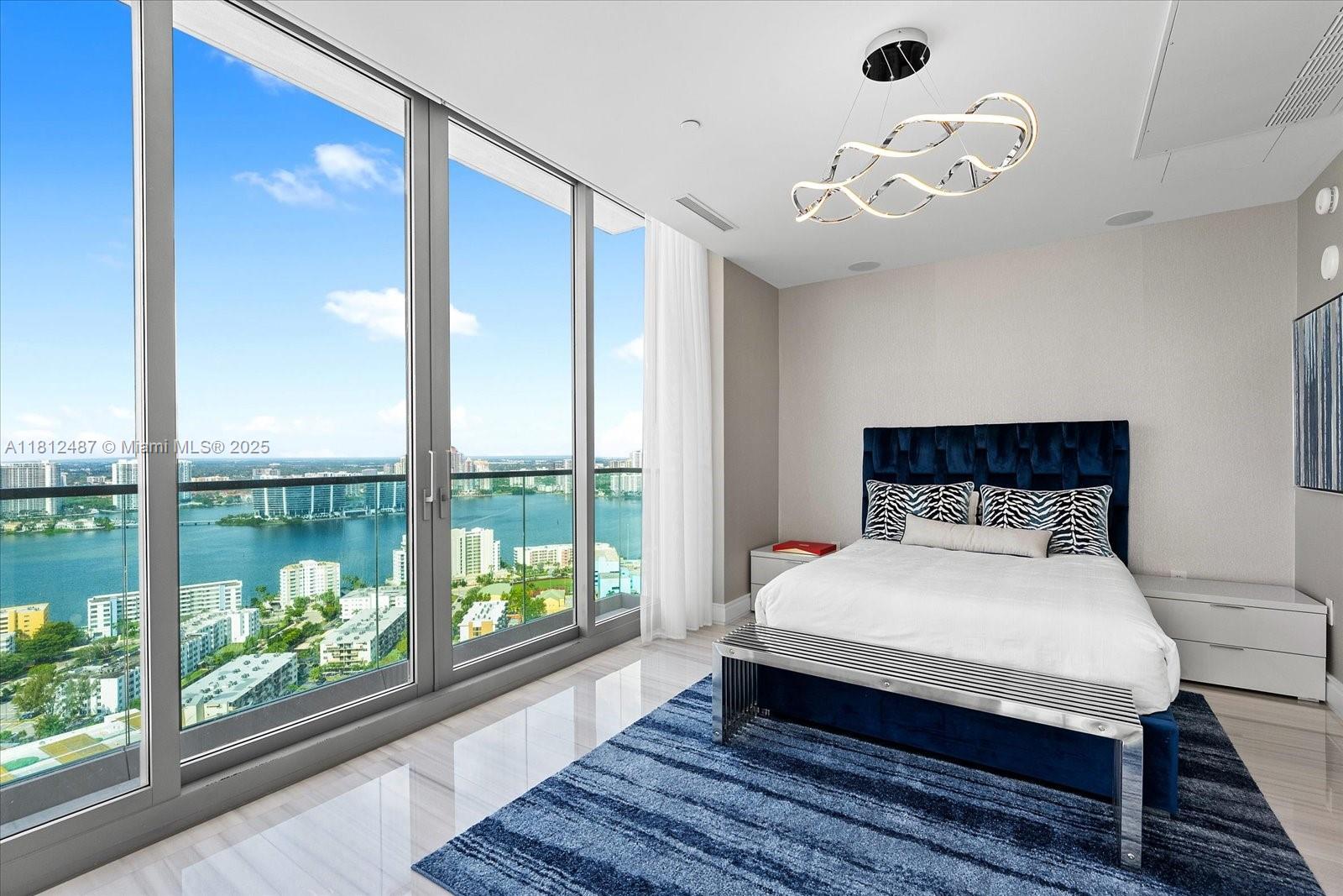 17901 Collins Avenue, Unit 3004 Sunny Isles Beach, FL 33160 - Photo 37 of 61 a bedroom with a large bed and a large window with outer view