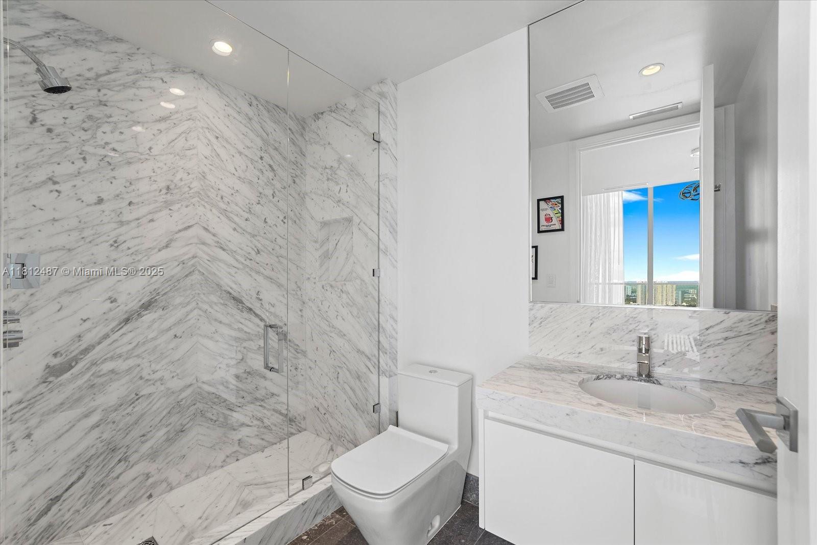 17901 Collins Avenue, Unit 3004 Sunny Isles Beach, FL 33160 - Photo 38 of 61 a bathroom with a granite countertop sink a toilet and a mirror