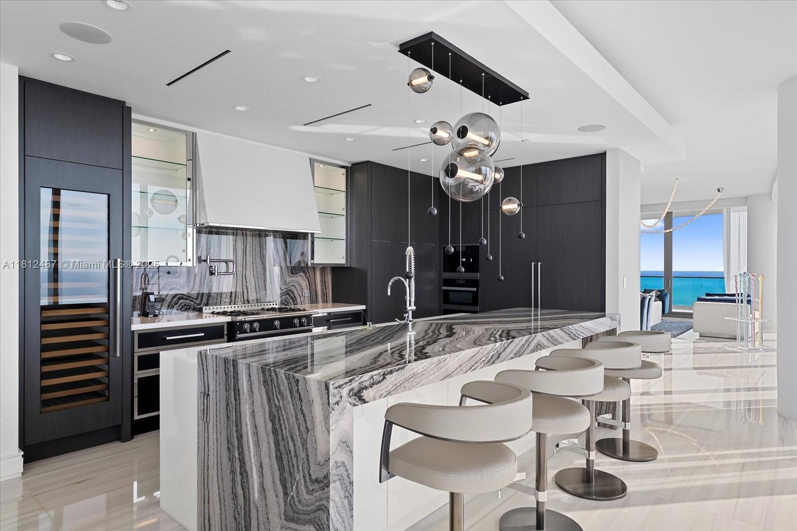 17901 Collins Avenue, Unit 3004 Sunny Isles Beach, FL 33160 - Photo 9 of 61 a kitchen with stainless steel appliances kitchen island granite countertop a sink and cabinets
