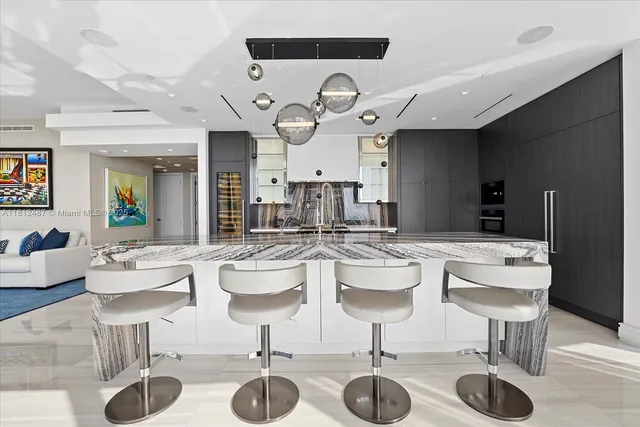 a large kitchen with stainless steel appliances kitchen island granite countertop a table chairs in it and wooden floors