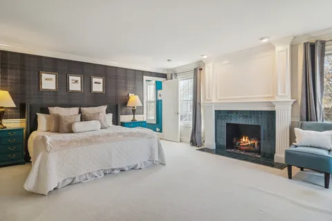 a spacious bedroom with a balcony a bed and a fireplace
