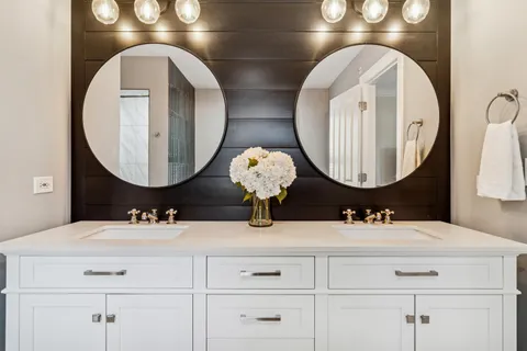 a bathroom with double vanity sinks and a mirror
