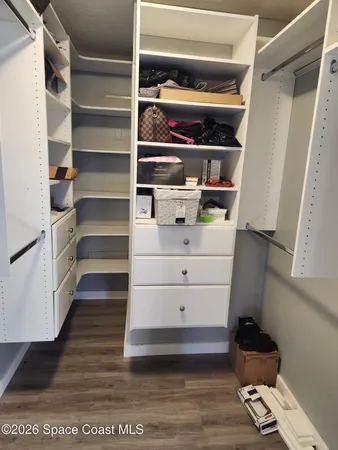 a view of walk in closet with empty racks