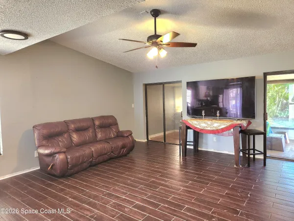 a living room with furniture and a wooden floor