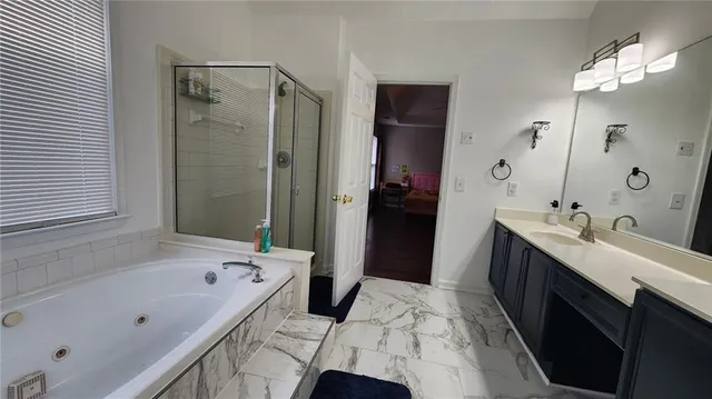 a bathroom with a tub sink and mirror