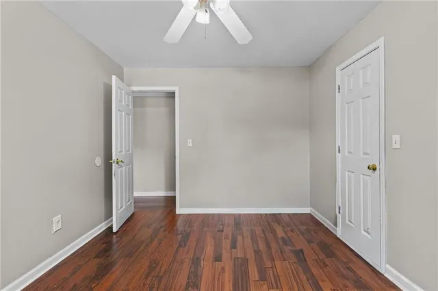 a view of a hallway with wooden floor and a chandelier