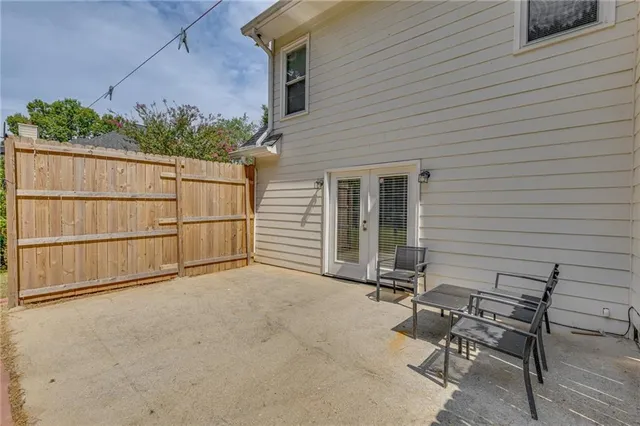 a view of a backyard with a chair and potted plants