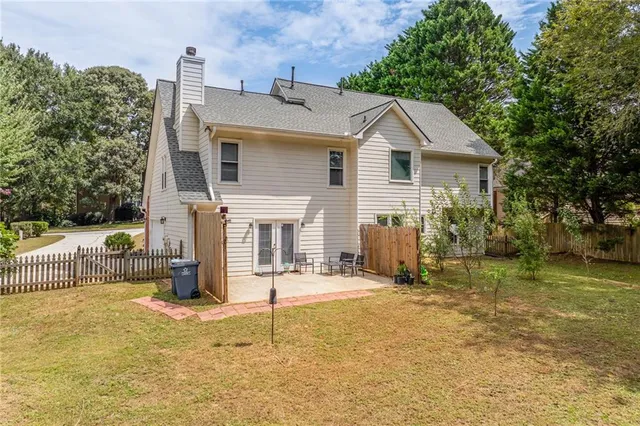 a view of a house with backyard and a tree