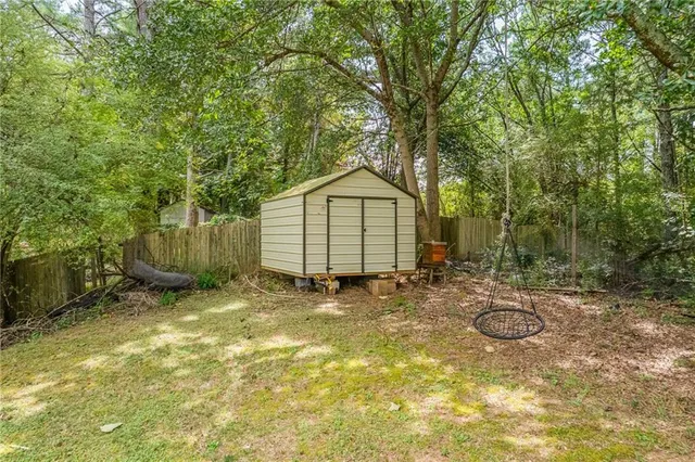 a backyard of a house with a large tree and wooden fence