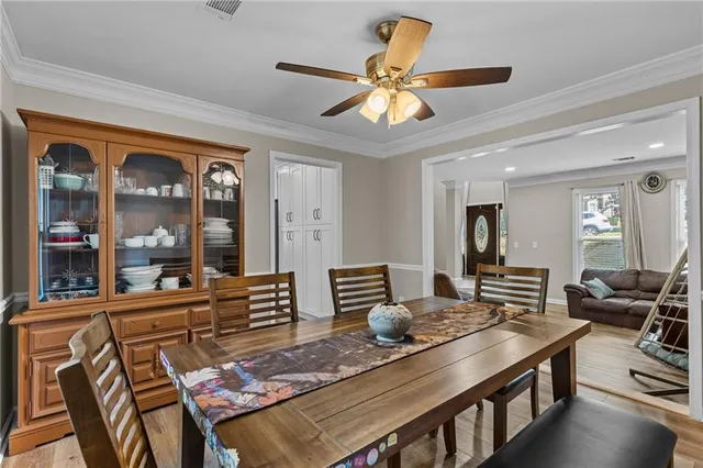 a view of a dining room and livingroom with furniture wooden floor a chandelier